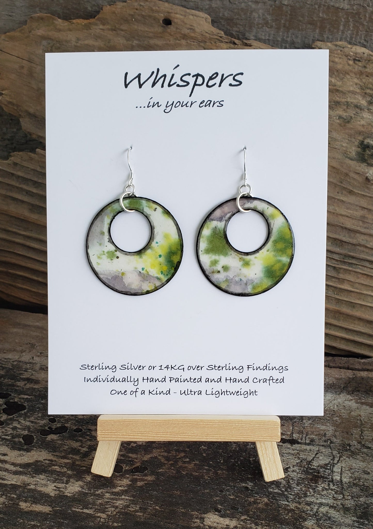 Hand painted watercolor ultra lightweight paper earrings. Abstract deign of ice covered greens. Circular in shape with circular cut out. Grey painted edges. Back is painted in black. Sterling silver findings. Hangs 1 1/2" in Length