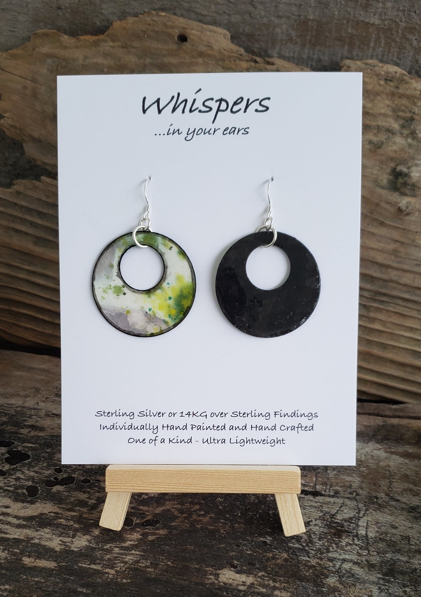Hand painted watercolor ultra lightweight paper earrings. Abstract deign of ice covered greens. Circular in shape with circular cut out. Grey painted edges. Back is painted in black. Sterling silver findings. Hangs 1 1/2" in Length