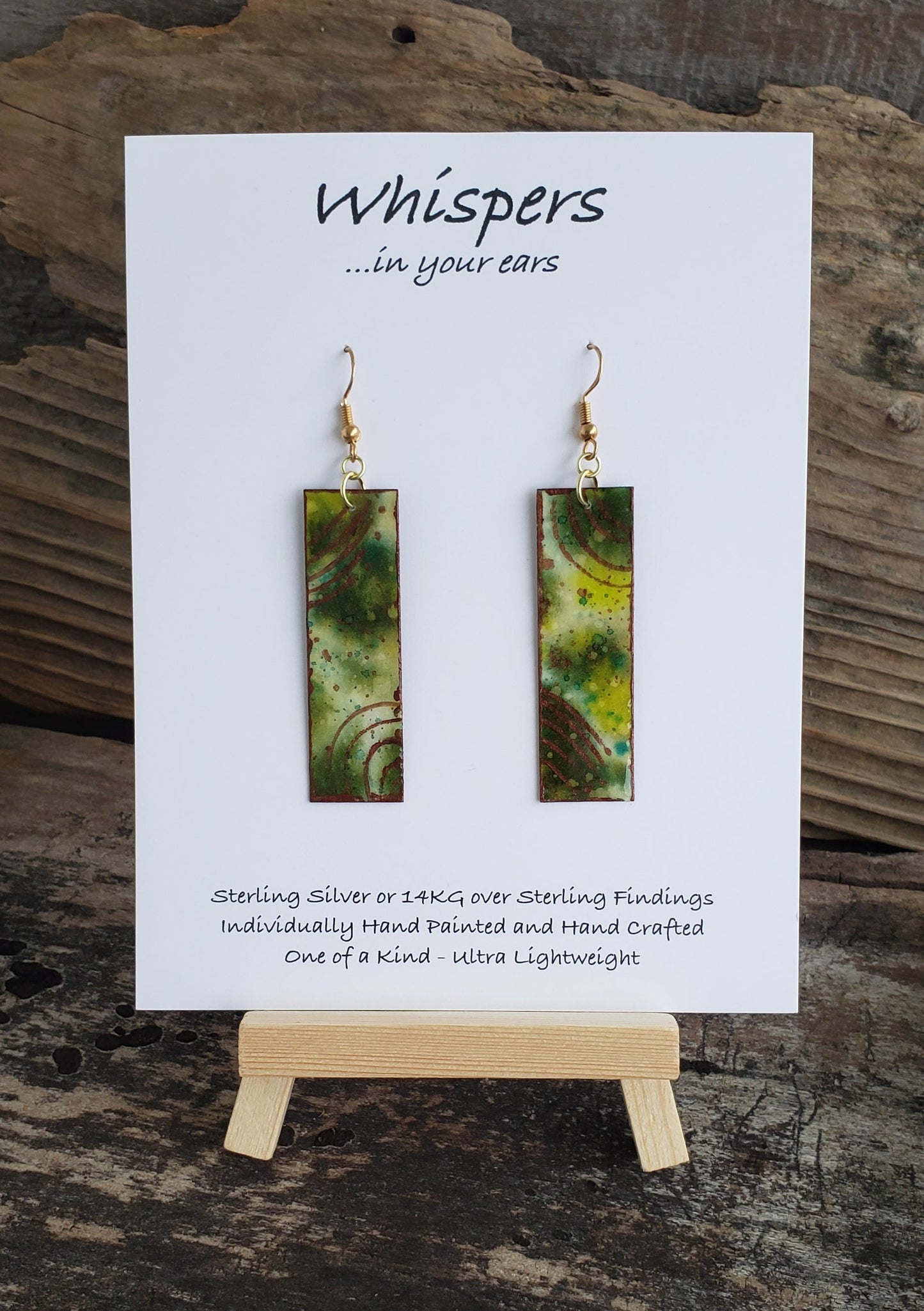 Hand painted watercolor ultra lightweight paper earrings. Muted green tones with copper painted accent rings. Back is painted copper in color. Elongated rectangle in shape. 14kg over silver findings. Hangs 2 1/4" in Length