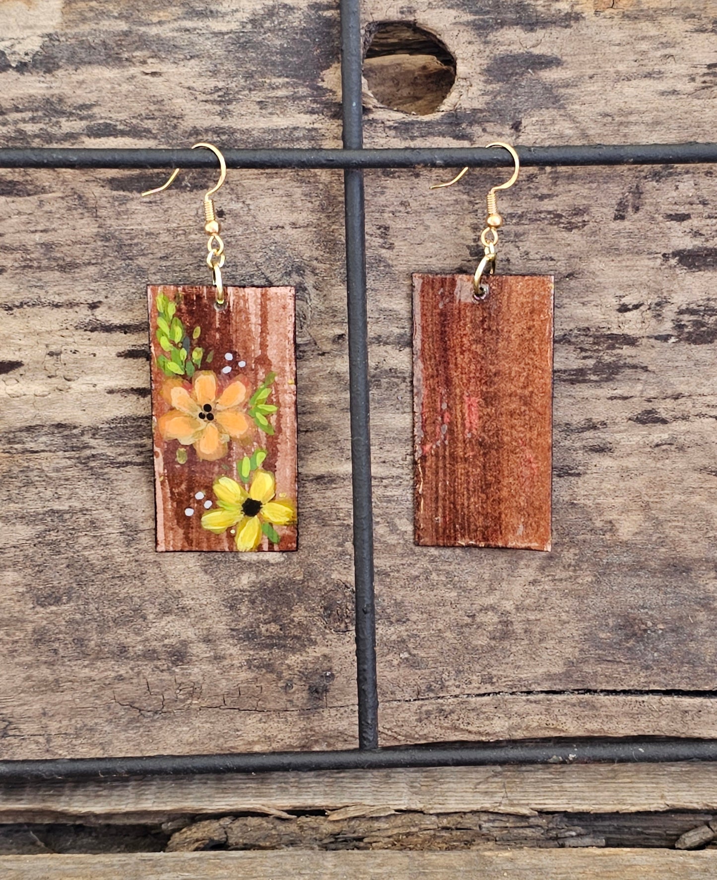 Hand painted Watercolor and Acrylic Floral Duo. Ultra lightweight paper earrings. Faux wood background with Pale yellow and Peach flowers . Edged in brown. Back is painted in complimentary color. Rectangular in shape. 14kg over sterling silver findings. Hangs 2 1/8" in Length