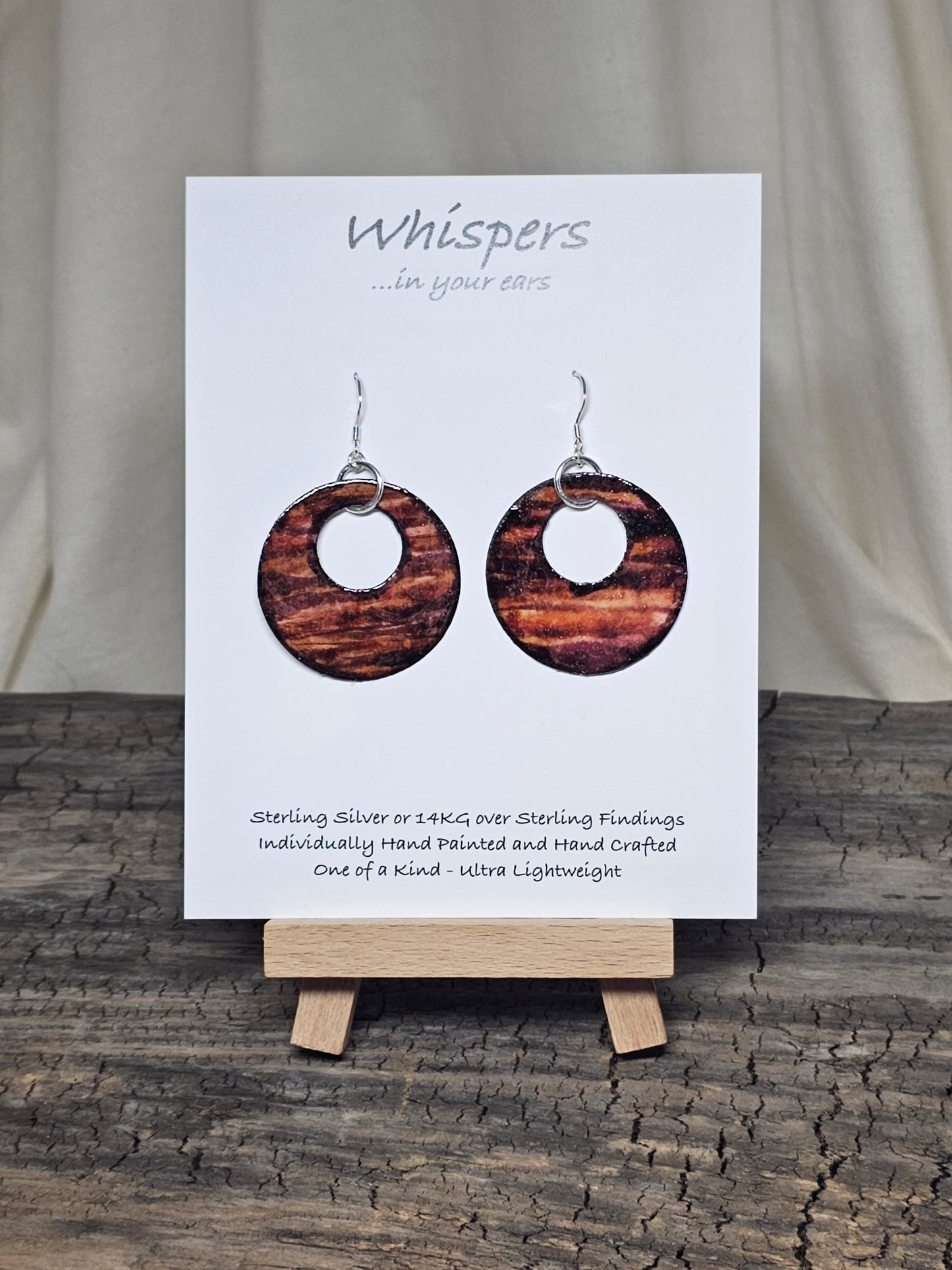Rustic Faux Wood Circles Hand Painted Paper Earrings. Dark and medium brown in watercolor. Espresso painted edge detail. 1 1/2" Circular in shape with circular cut out. Sterling Silver findings. Hangs 1 3/4" in length