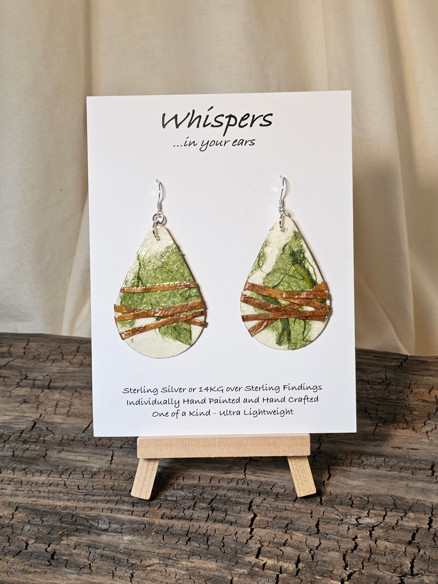 Off White and Green Faux Leather Wrapped Handcrafted Paper Earrings. Ultra lightweight. Created from handmade papers. Various shades of green. Faux leather strap wrap. Back is the same colors and design. 2" Tear drop shape. Sterling silver findings. Hangs 2 1/2" in length