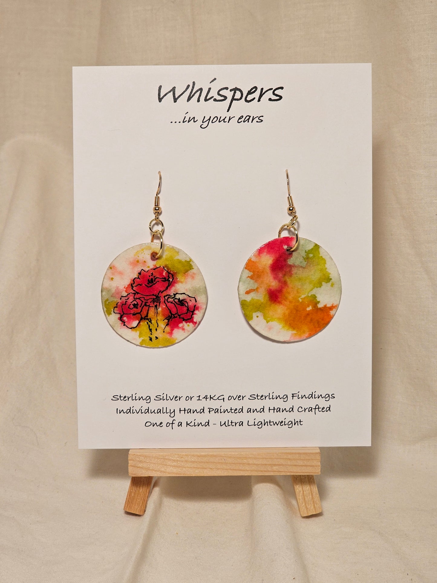 Pink Poppy Trio Hand Painted Paper Earrings. 1 1/2" Circle . Lime green and Hot pink Poppies. Back is painted in complimentary colors. Resin coating for durability. 14KG over sterling silver findings. Hangs 1 3/4" length