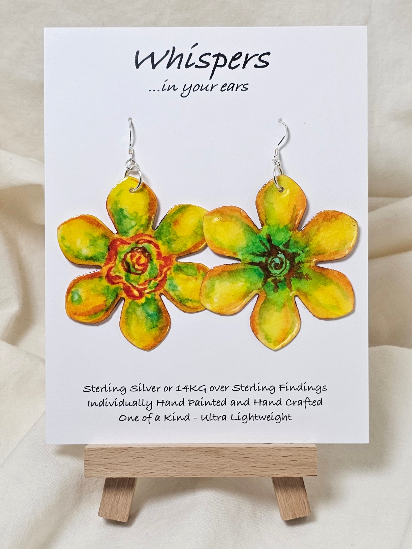 Pop Art Daffodil Flower Hand Painted Paper Earrings. Ultra lightweight 2 1/2" in diameter. Watercolor painted to resemble bright yellow and orange daffodil. Back is painted in complimentary colors. Resin Coating for durability. Sterling Silver findings. Hangs 2 5/8" in length