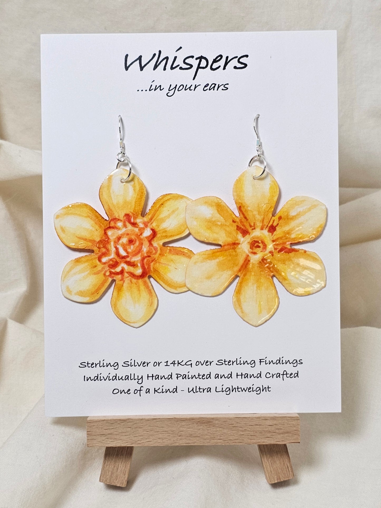 Tangerine Daffodil Flower Hand Painted Paper Earrings. Ultra lightweight 2 1/2" in diameter. Watercolor painted to resemble bright yellow and orange daffodil. Back is painted in complimentary colors. Resin Coating for durability. Sterling Silver findings. Hangs 2 5/8" in length