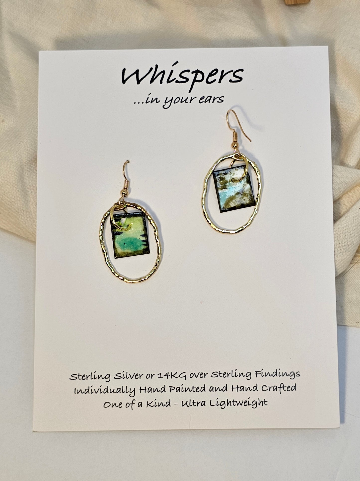 Gold Alloy Oval Mini Hand Painted Paper Earrings. Small painting in Aqua blue, brown, black and lime green. Hanging from the center of Gold alloy oval. Back is painted to match. Ultra lightweight. Resin coating for durability. 14KG over sterling findings. Hangs 1 1/4" in length
