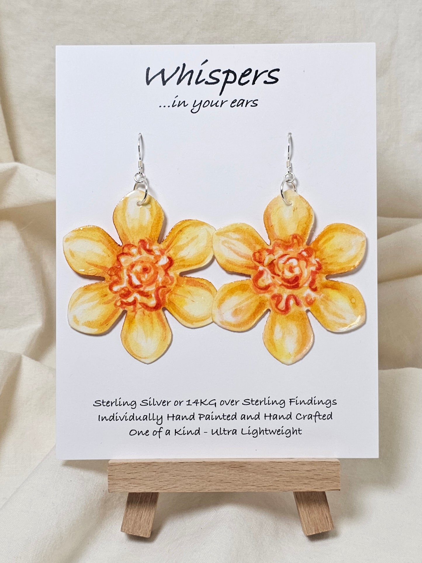 Tangerine Daffodil Flower Hand Painted Paper Earrings. Ultra lightweight 2 1/2" in diameter. Watercolor painted to resemble bright yellow and orange daffodil. Back is painted in complimentary colors. Resin Coating for durability. Sterling Silver findings. Hangs 2 5/8" in length