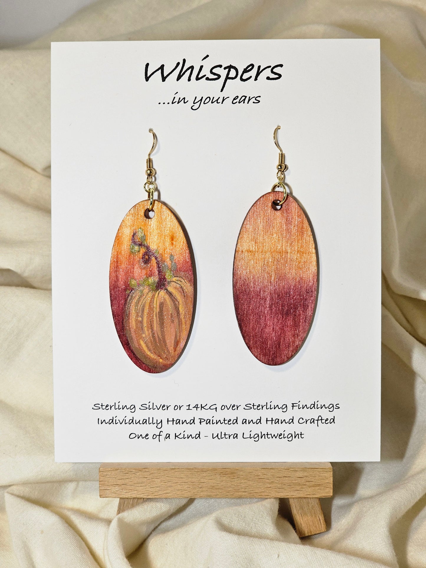 Pumpkin Glow Hand Painted Wood Earrings. Ombre background orange and red. Back painted in similar colors. Enameled for durability. 2" Elongated wood oval. 14kg over sterling silver findings and hangs 2 1/4"