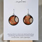 Hand painted Paper earrings. Embellished with acrylics. Look of white dot with black, orange and red lines. Ultra lightweight. 1 1/4 in diameter Sterling Silver findings. Hangs 1 1/2" in length
