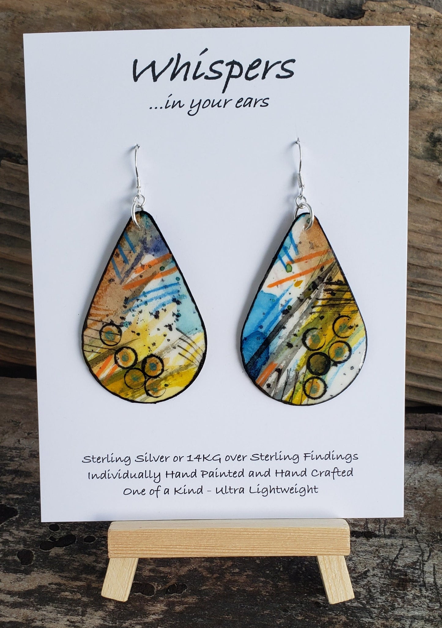 Hand painted watercolor, pencil and acrylic media mix. Ultra lightweight paper earrings. Orange, yellows blues and blacks. Painted black edges. Back is painted in similar style. Teardrop in shape. Sterling silver findings. Hangs 2 1/4" in Length