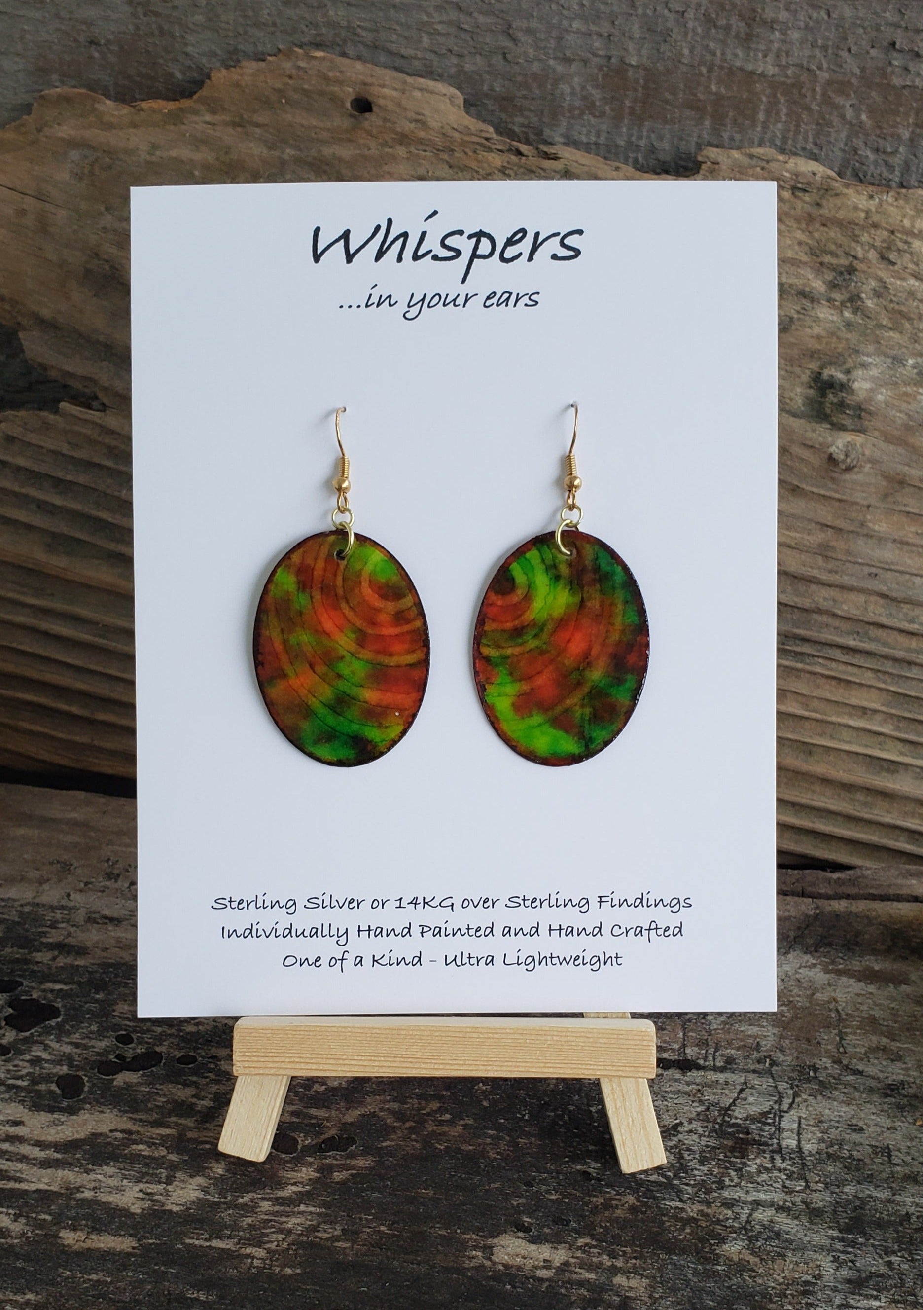 Hand painted watercolor ultra lightweight paper earrings. Shades of red and green with negative space ring lines. Back is painted in a similar complimentary colors. Oval in shape. Hangs 1 1/4" in Length
