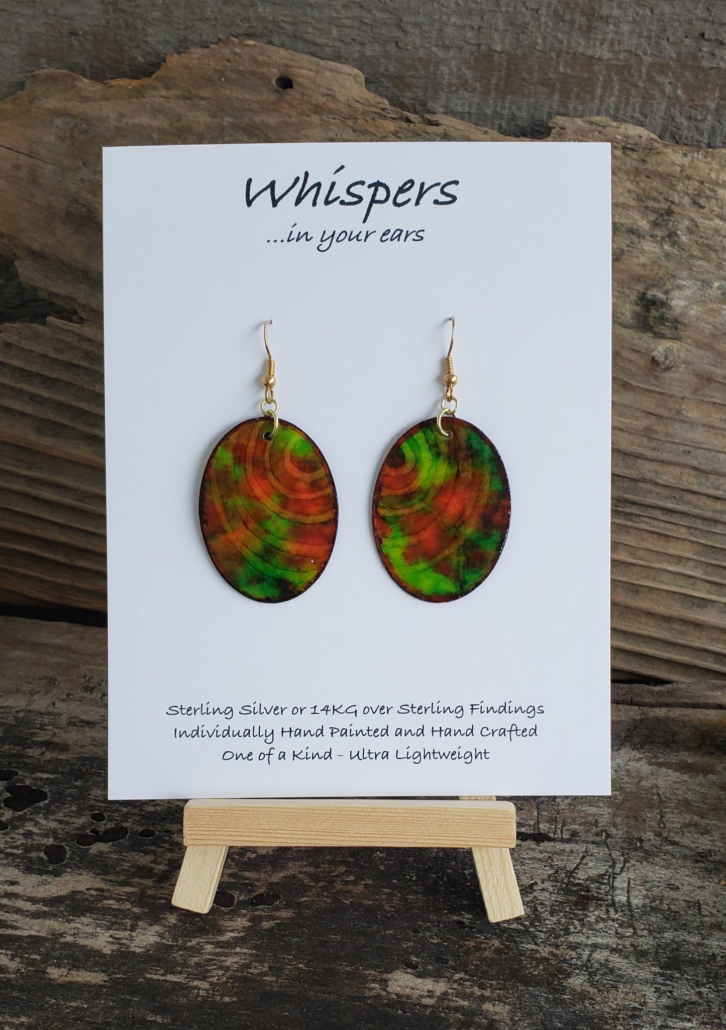 Hand painted watercolor ultra lightweight paper earrings. Shades of red and green with negative space ring lines. Back is painted in a similar complimentary colors. Oval in shape. Hangs 1 1/4" in Length