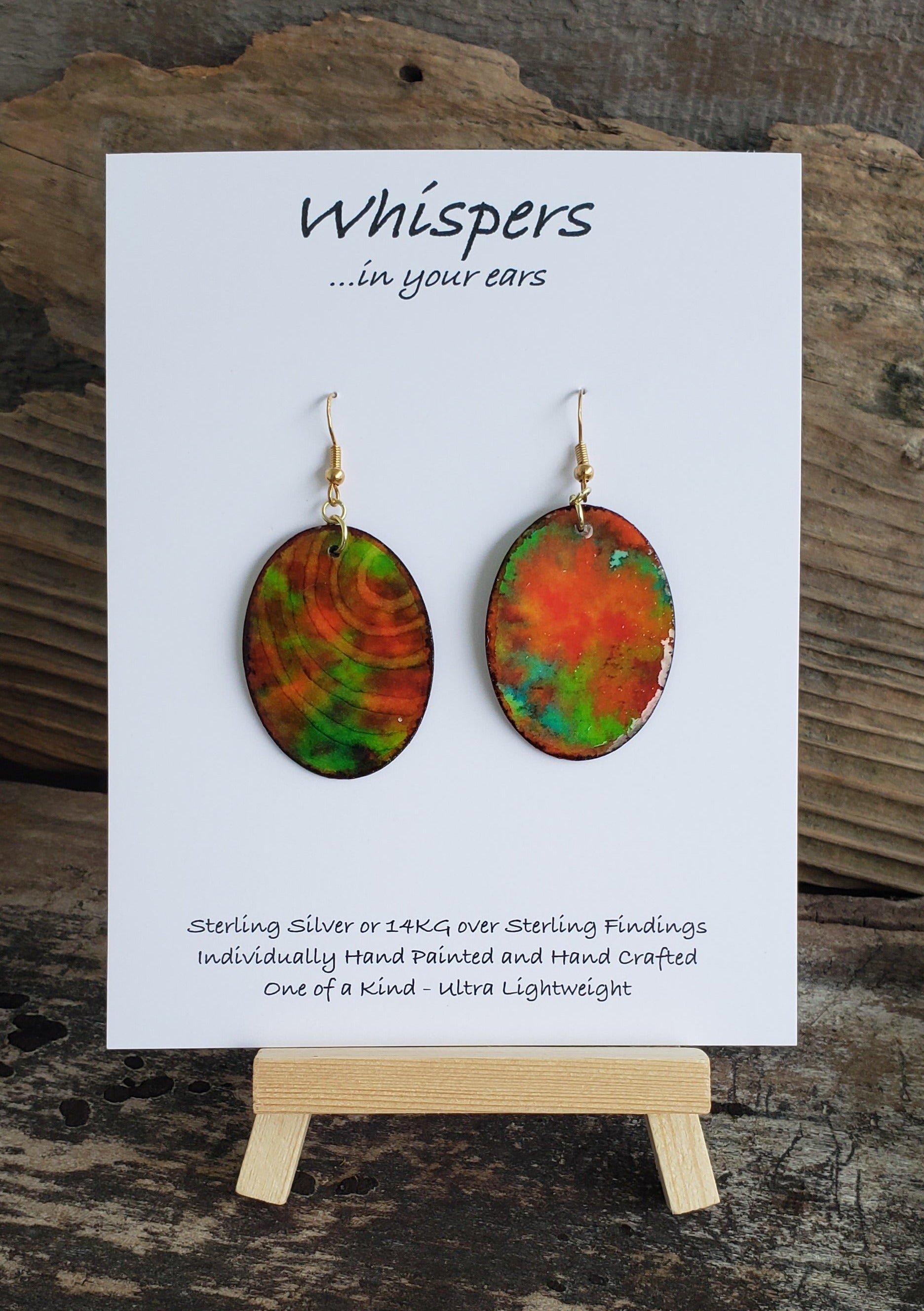 Hand painted watercolor ultra lightweight paper earrings. Shades of red and green with negative space ring lines. Back is painted in a similar complimentary colors. Oval in shape. Hangs 1 1/4" in Length