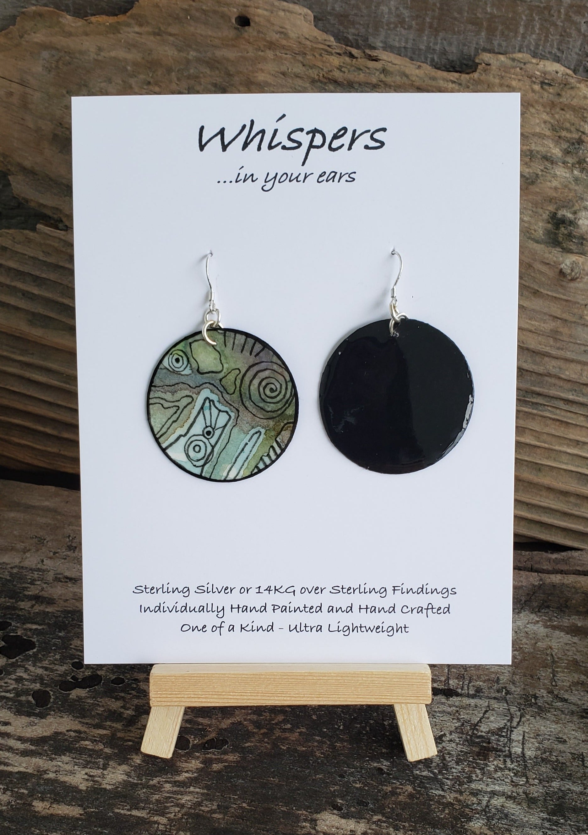 Hand painted water ultra lightweight paper earrings. Muted greens, blues and red accented by black linear shapes. Back is painted in black a complimentary color. Circular in shape. Hangs 1 3/4" in Length