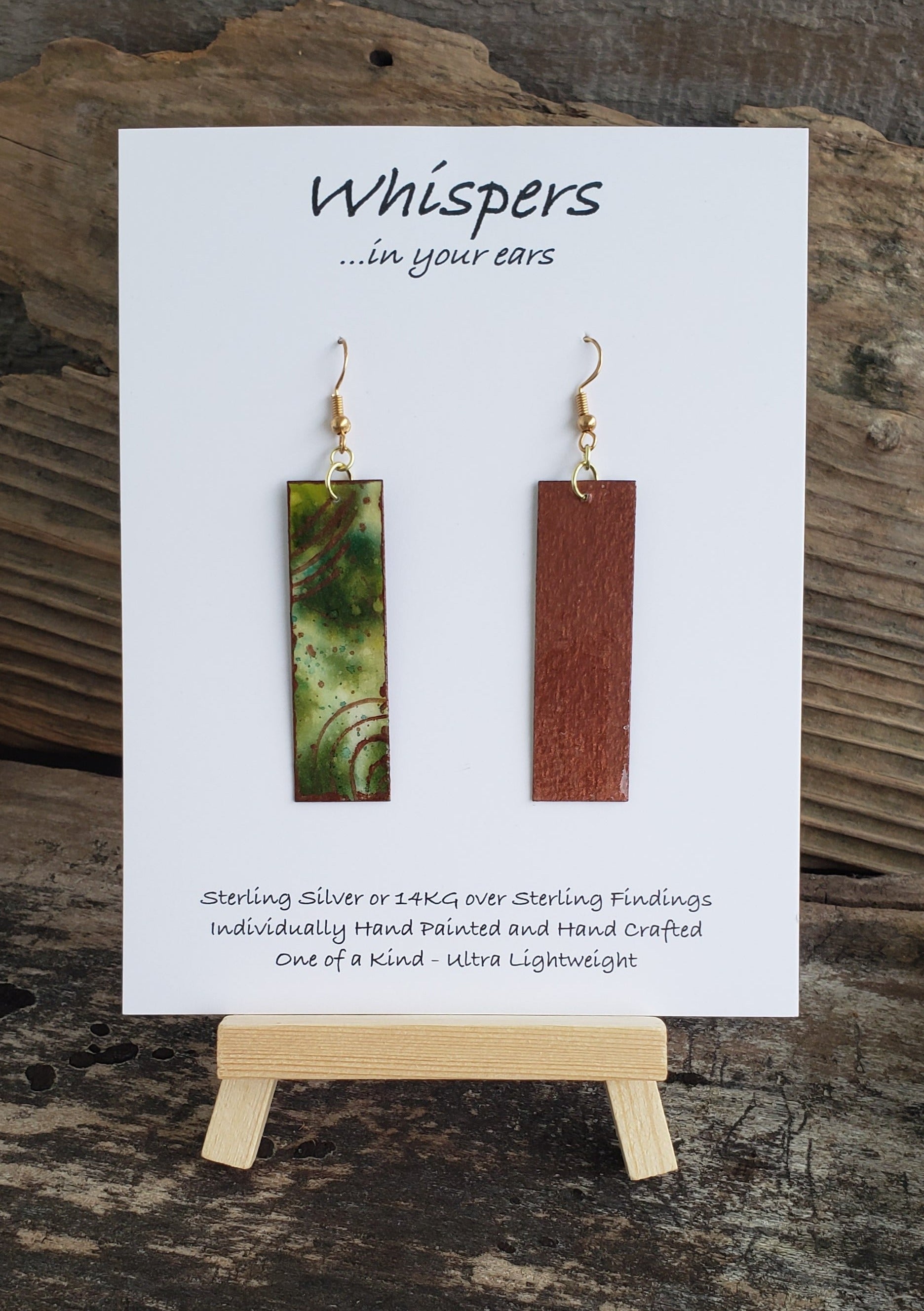 Hand painted watercolor ultra lightweight paper earrings. Muted green tones with copper painted accent rings. Back is painted copper in color. Elongated rectangle in shape. 14kg over silver findings. Hangs 2 1/4" in Length