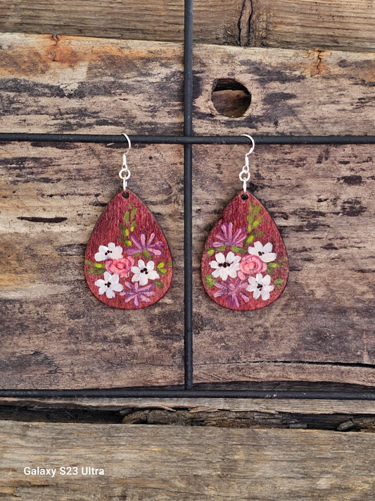 Hand Painted Ultra Lightweight Wooden Earrings. Watercolor and Acrylic.  Plum colored  background. Muted white lilies, pink roses, purple chrysanthemums design. Teardrop in shape. Back is painted in complimentary color. Sterling Silver Findings. Hangs 2 1/4" in Length