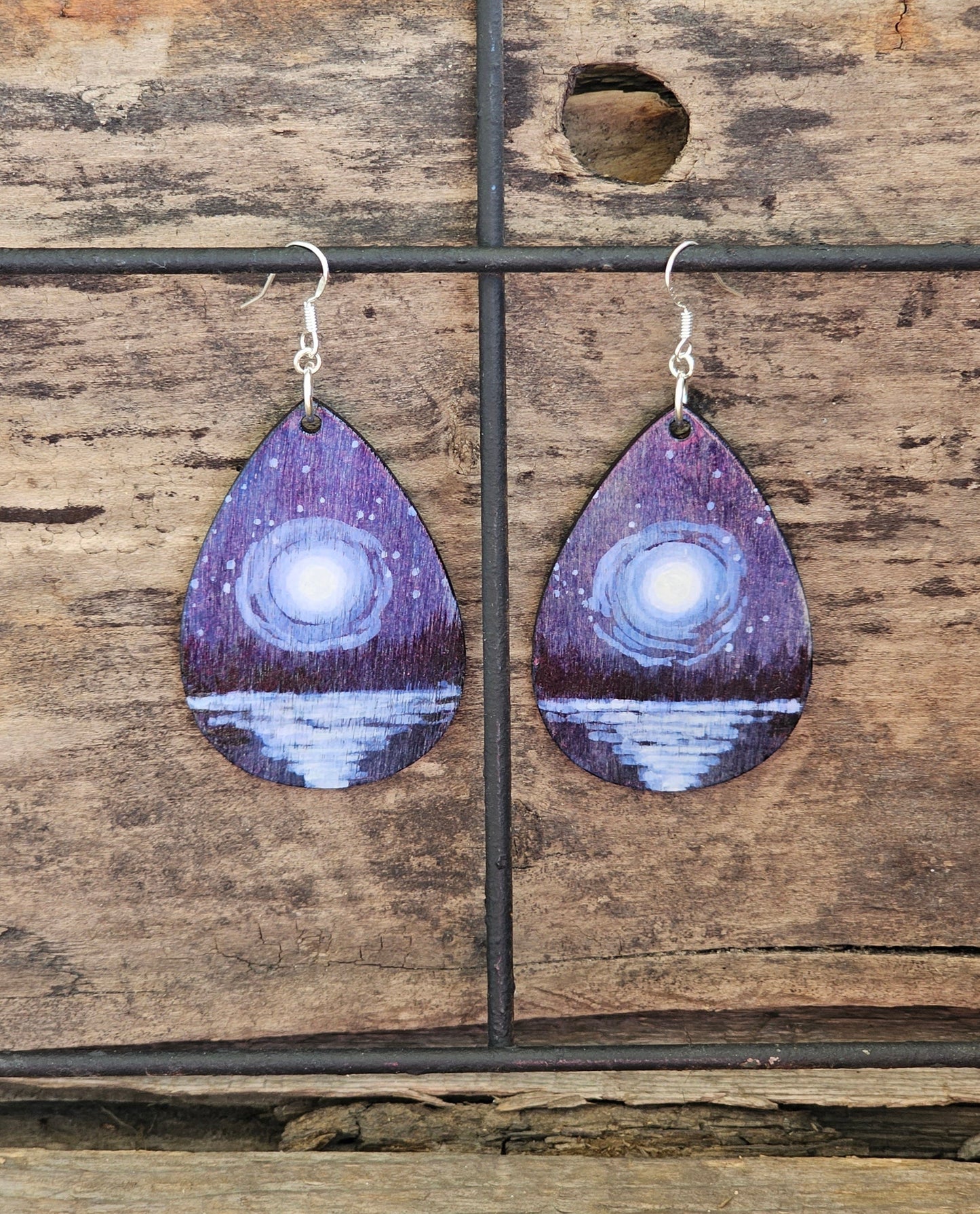 Hand Painted Ultra Lightweight Wooden Earrings. Watercolor and Acrylic.  Multi toned Blue colored background. Moonscape Reflection over water . Teardrop in shape. Back is painted in complimentary color. Sterling Silver Findings. Hangs 2 1/4" in Length