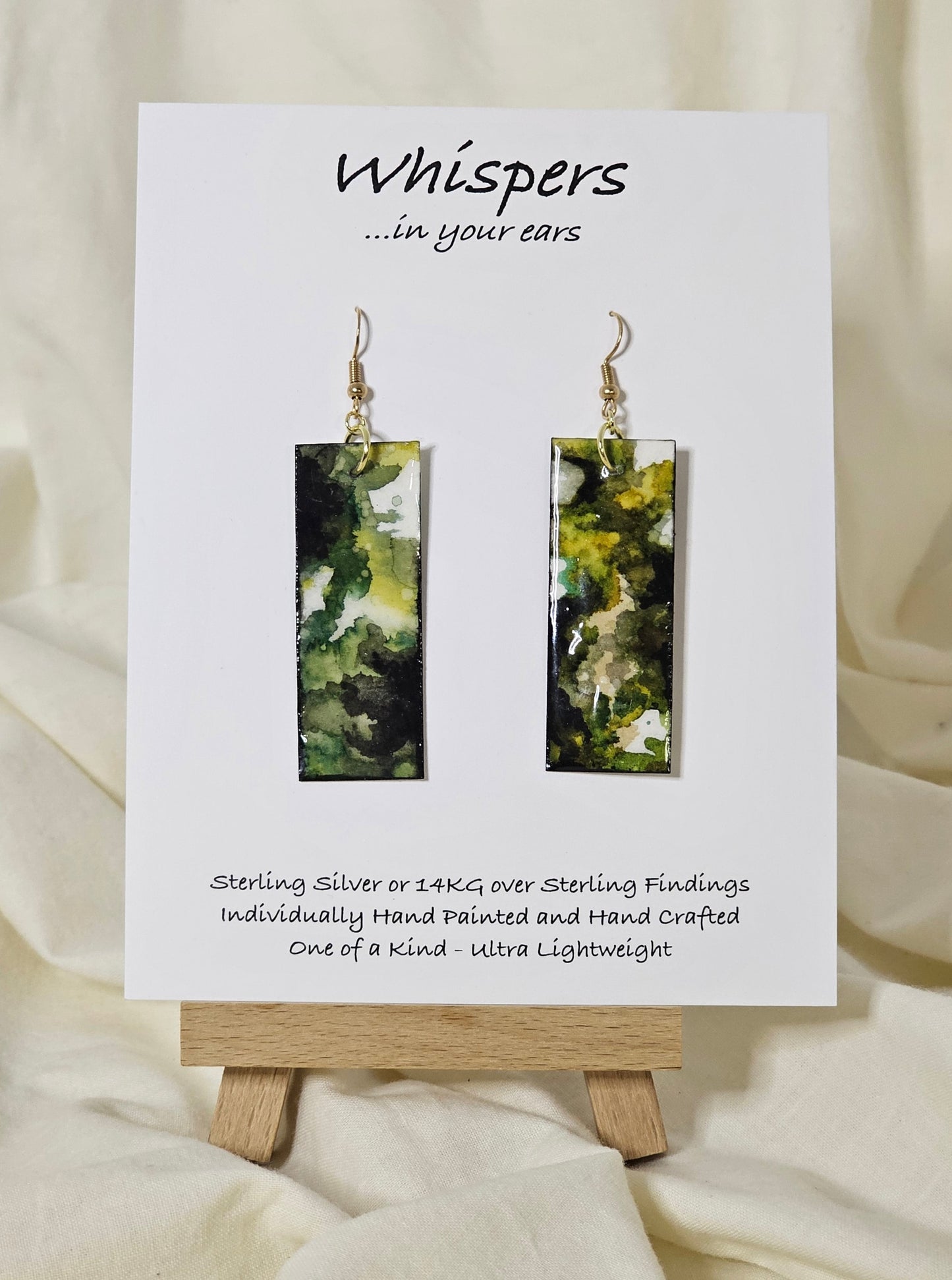 Hand painted watercolor and acrylic ultra lightweight paper earrings. Muted green tones with varying shades of green. Back is painted with similar design and color. Elongated rectangle in shape. 14kg over silver findings. Hangs 2 1/4" in Length