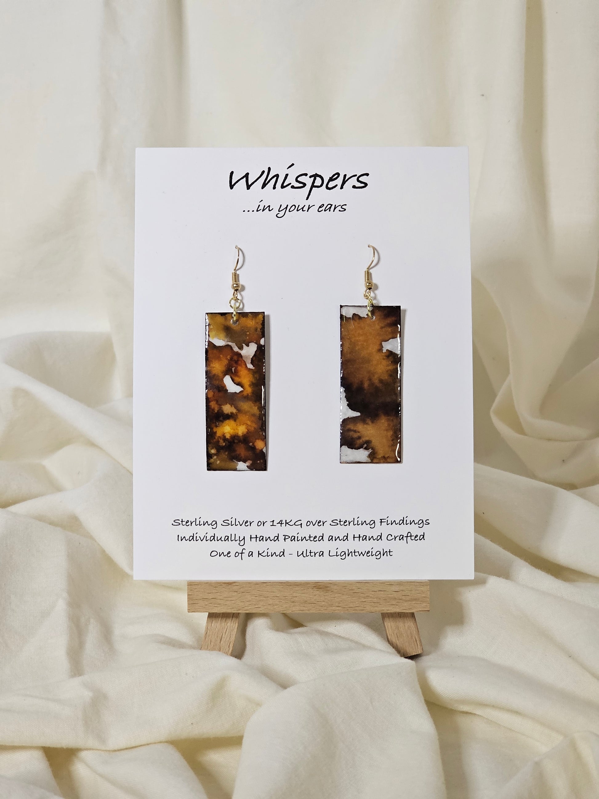 Hand painted watercolor ultra lightweight paper earrings. Muted brown, golden honey and espresso tones. Back is painted with similar design and color. Elongated rectangle in shape. 14kg over silver findings. Hangs 2 1/4" in Length