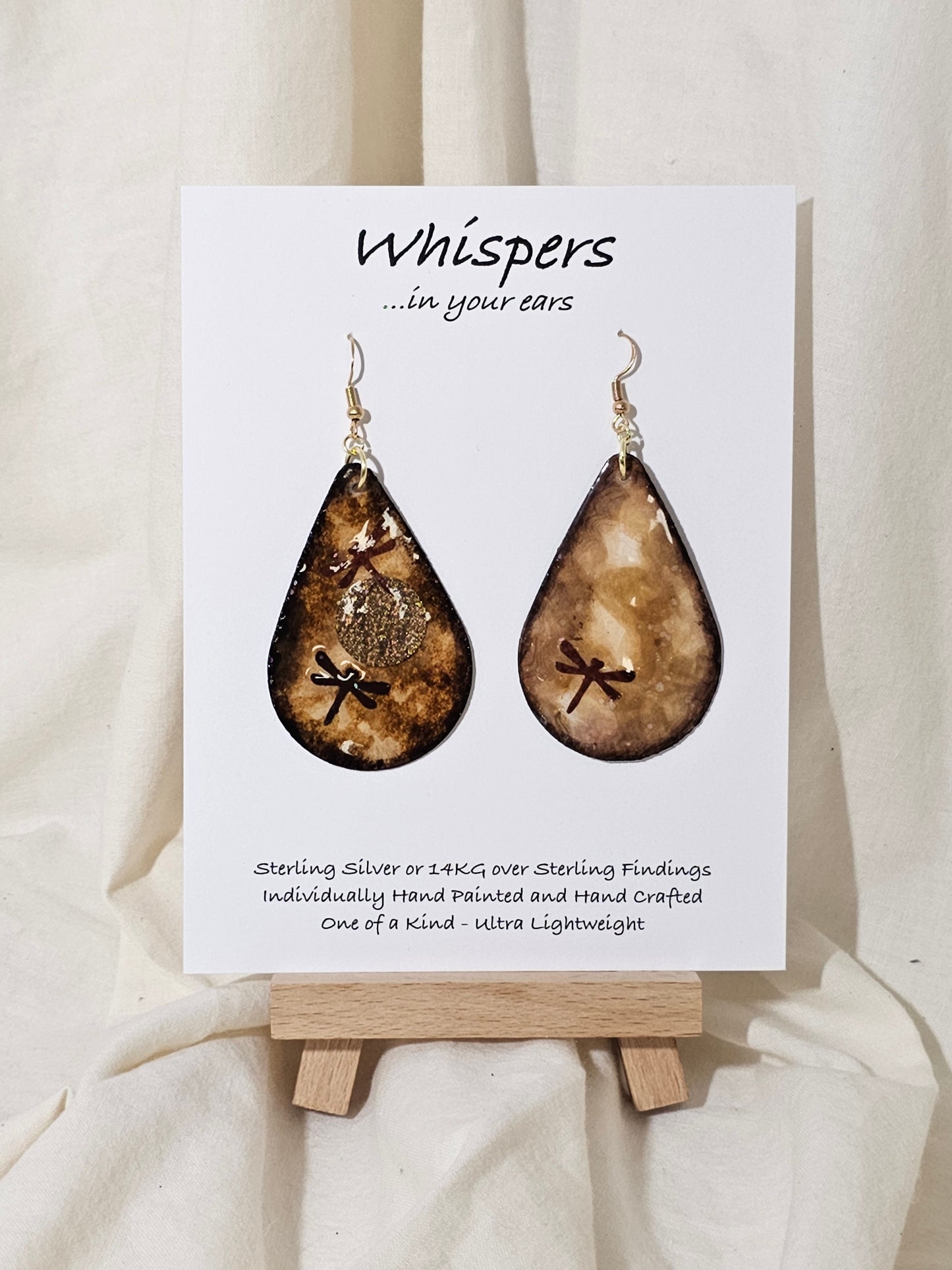 Hand painted watercolor ultra lightweight paper earrings. Brown cream and Espresso tones. Dark Brown Painted edges. Paper Dragonfly embellishments. Metallic Sun shape. Back is painted with similar colors. Teardrop in shape. 14kg over silver findings. Hangs 2 1/4" in Length