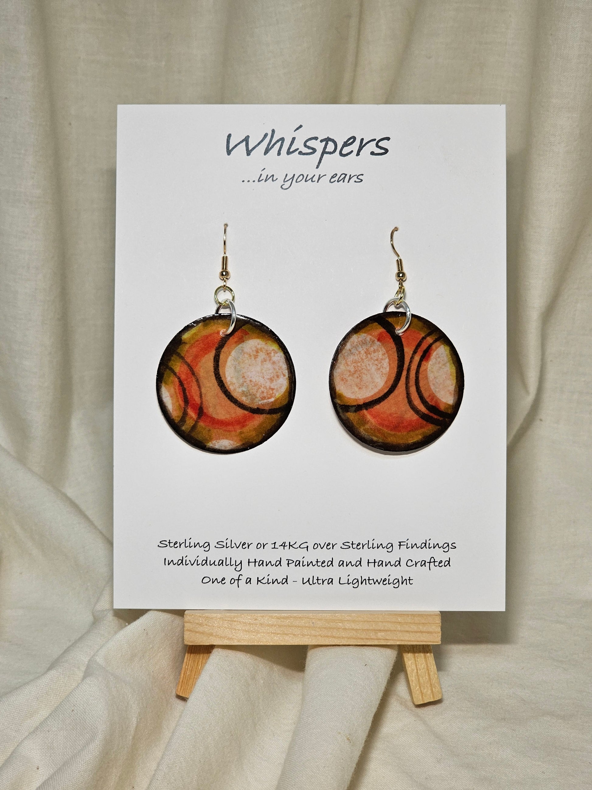 Hand painted Paper earrings. Embellished with acrylics. Look of white dot with black, orange and red lines. Back of earring is painted to match. Ultra lightweight. Resin coated for durability.&nbsp; 1 1/2 in diameter Mix metals Sterling Silver and 14KG over Sterling findings. Hangs 1 3/4" in length