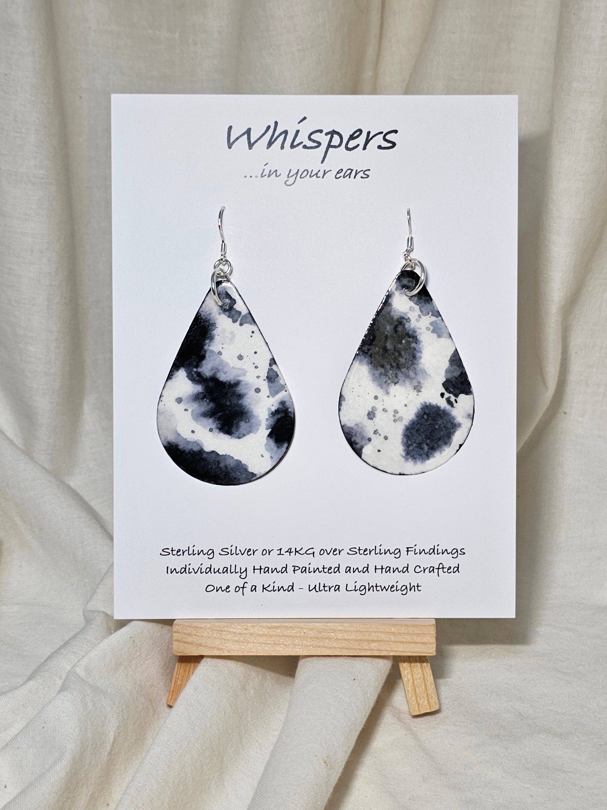 Black Cow Hide hand painted watercolor paper earrings. Ultra lightweight, 2 1/8" Tear Drop.&nbsp; Back is painted to match. Resin coating for durability. Sterling Silver findings. Hangs 2 1/2" in length.