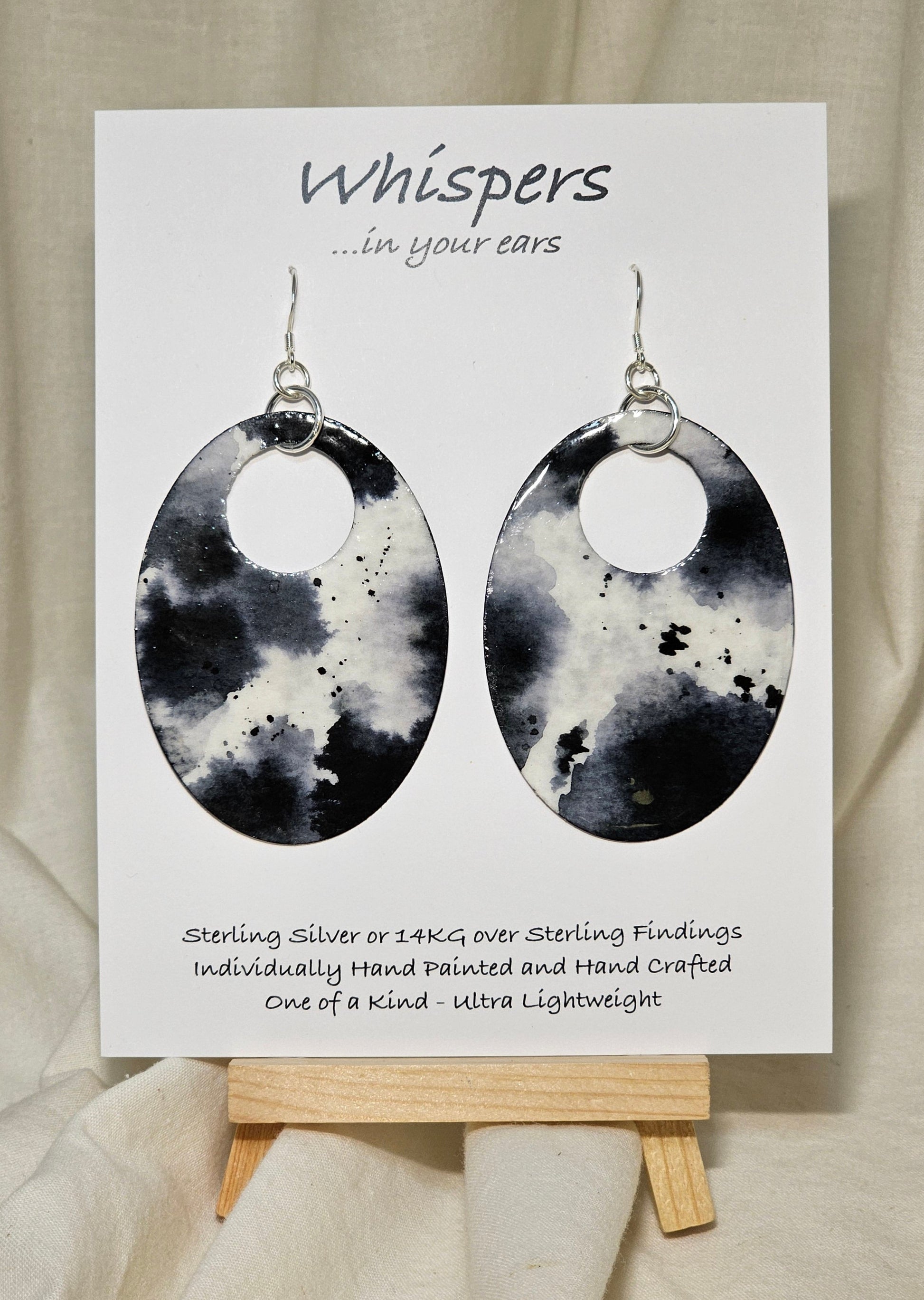 Black n White Cow Hide Print. Hand Painted Paper Earrings. Ultra lightweight, Large statement 2 1/2" Oval. Back is painted to match. Resin coating for durability. Sterling Silver findings. Hangs 2 3/4" in length