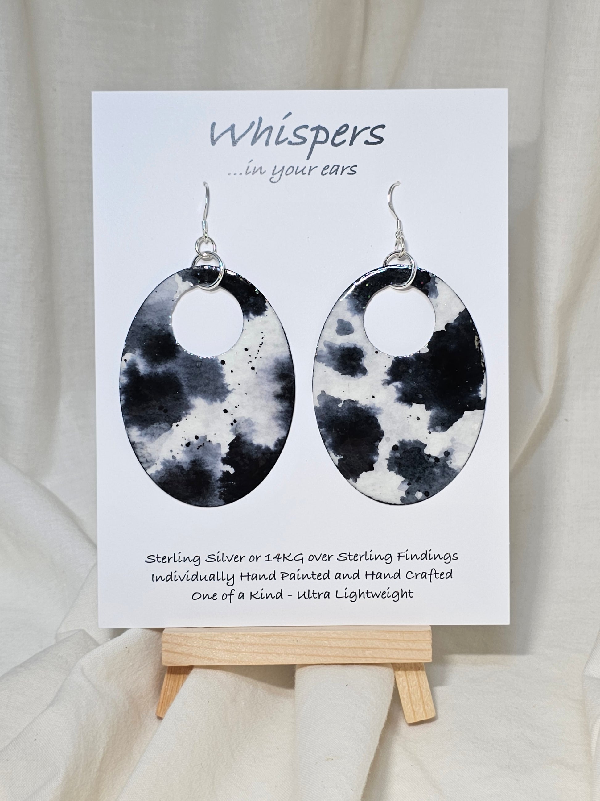 Black n White Cow Hide Print. Hand Painted Paper Earrings. Ultra lightweight, Large statement 2 1/2" Oval. Back is painted to match. Resin coating for durability. Sterling Silver findings. Hangs 2 3/4" in length