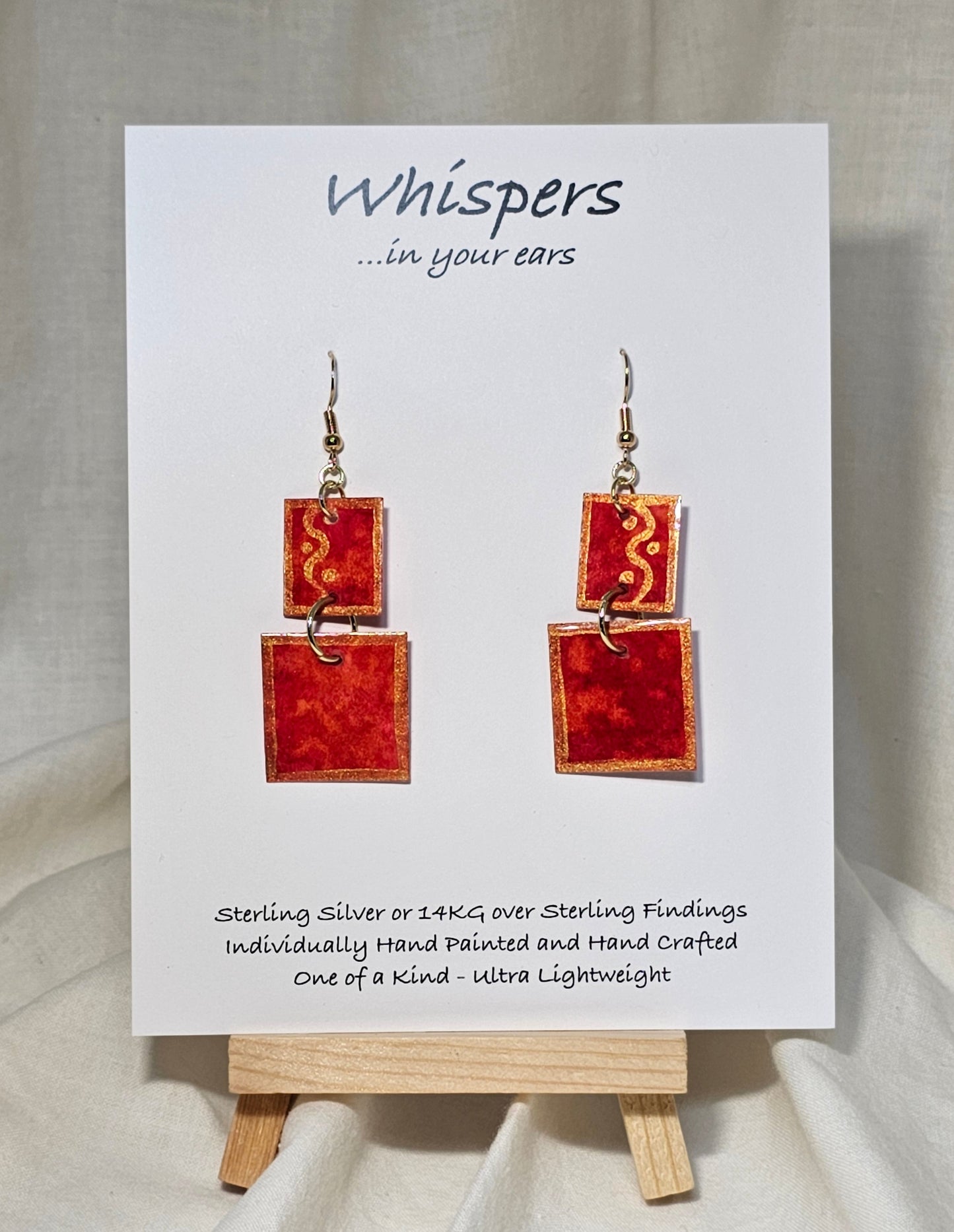 Red n Gold Squared Hand Painted Paper Earrings. 2 Piece dangle red and gold watercolor. Mid size 3/4" and 1" squares. Back is painted to match. Resin coating for durability. 14KG over sterling findings. Hangs 1 7/8" in length