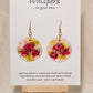Pink Poppy Trio Hand Painted Paper Earrings. 1 1/2" Circle . Lime green and Hot pink Poppies. Back is painted in complimentary colors. Resin coating for durability. 14KG over sterling silver findings. Hangs 1 3/4" length
