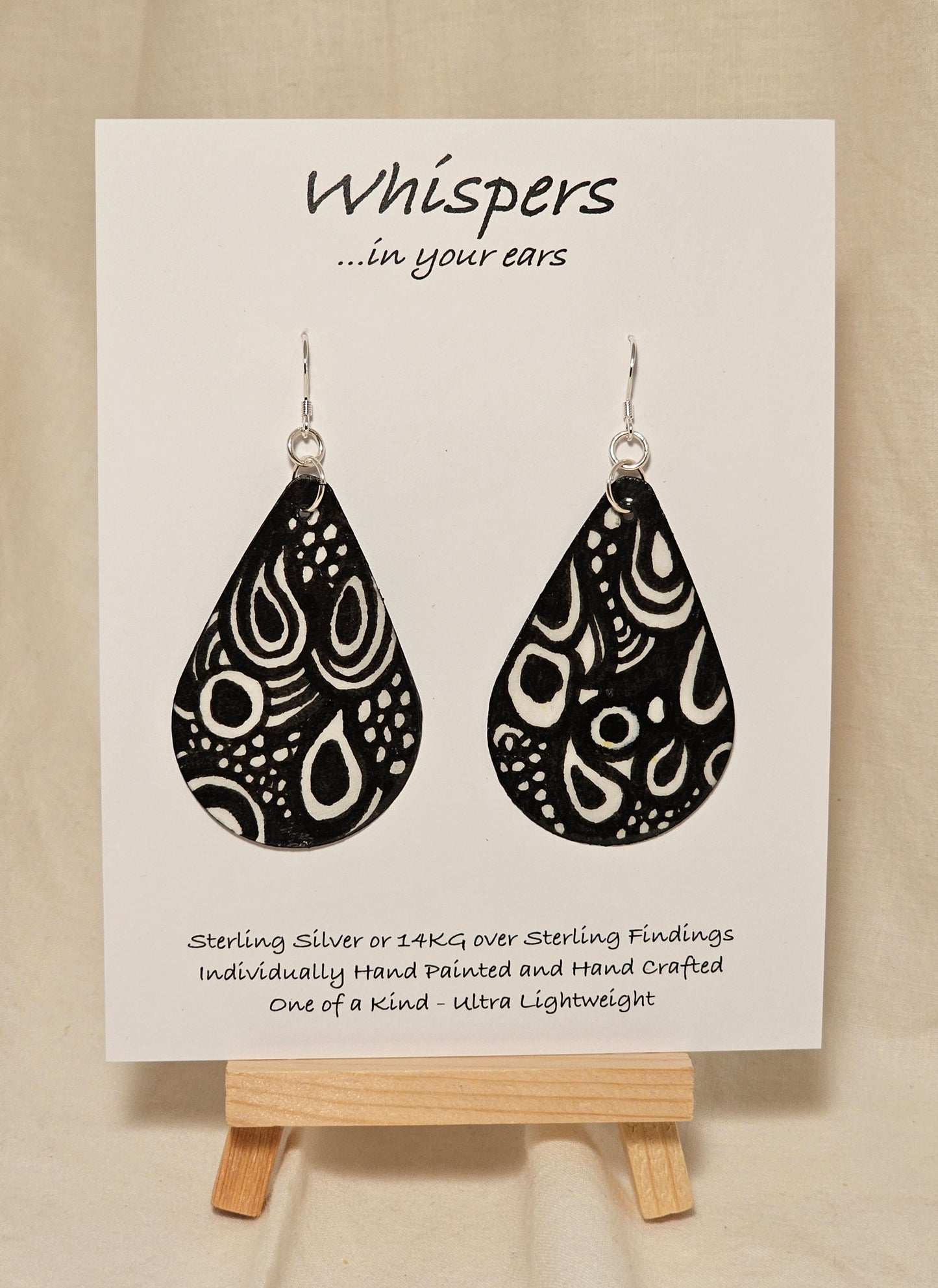 Black n White Swirls n Dots and Painted Paper Earrings. 2 1/8" Tear Drop shape. Abstract white swirls on black background. Back is Grey dots and similar design. Resin coating for durability. Sterling silver findings. Hangs 2 1/2" in length