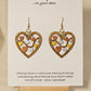 Metallic Hearts Wood Die cut hand Painted Earrings. Small hearts on a vine individually painted in gold, silver and copper. Back is painted to match. 1 1/2" Heart. Enameled for durability. 14KG over sterling findings Hangs 1 3/4" in length