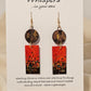 Metallic Confetti Hand Painted Paper and Wood Earrings. Paper hand painted Red with metallic accents. Hanging from embellished wooden disc. Back is painted to match. Resin coating for durability. Mixed metal findings. 14KG over sterling ear wires. Hangs 2 3/4" in length