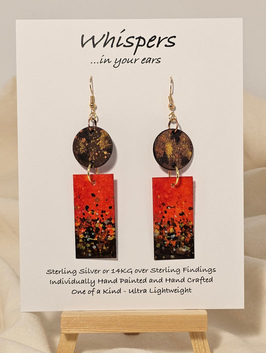 Metallic Confetti Hand Painted Paper and Wood Earrings. Paper hand painted Red with metallic accents. Hanging from embellished wooden disc. Back is painted to match. Resin coating for durability. Mixed metal findings. 14KG over sterling ear wires. Hangs 2 3/4" in length
