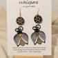 Bee Golden Wood Die Cut Hand Painted Earrings. Honeycomb in gold and black painted wood disc. Metallic painted bee wood die cut. Back is painted to match. Enameled for durability. 14KG over sterling silver findings. Hangs 3" in length
