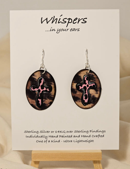 Pink Leopard Cross Hand Painted Paper Earrings. 1 1/2" Oval shaped, Leopard print background with pink leopard print cross. Back is leopard only. Resin coating for durability. Sterling Silver findings. Hangs 1 3/4" in length