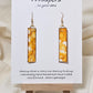 Yellow Citrine Geode Hand Painted Paper Earrings. 1/2" x 2" Elongated Rectangle painted in yellows and metallic gold, faux citrine geode. Edged in gold. Back is painted in similar design. Resin coating for durability. Mixed metal findings, 14KG over sterling wires. Hangs 2 1/4" in length