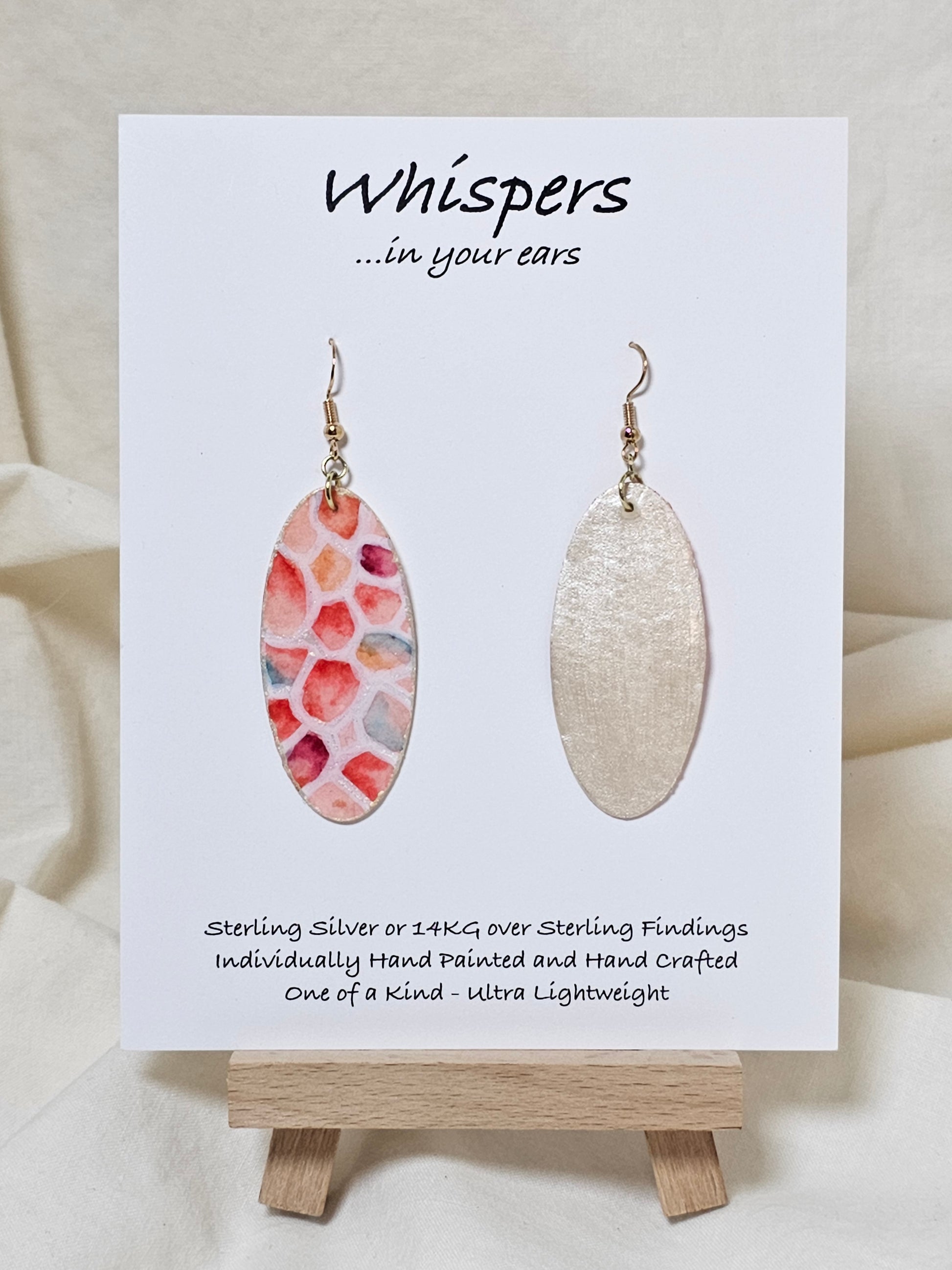 Wings Magnified Hand Painted Paper Earrings.&nbsp; Ultra lightweight 2" Elongated oval. Painted multicolored in pastels. Back is painted in white iridescent pearl. Resin coating for durability. Mixed metal findings Sterling silver and 14KG over sterling ear wires. Hangs 2 1/8" in length