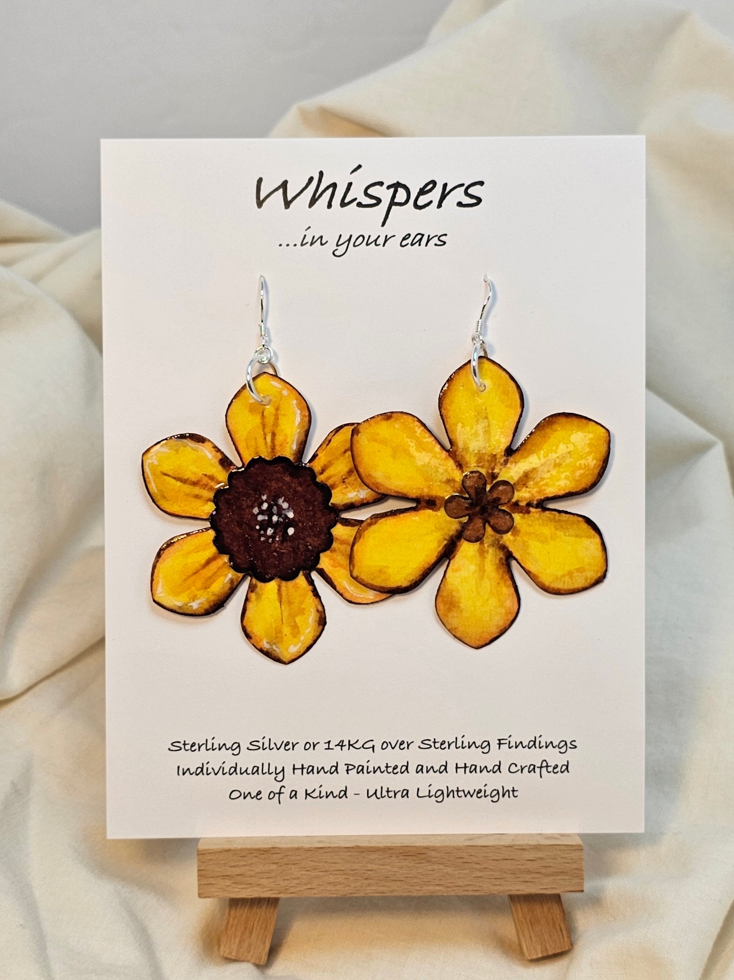 Sunflower Layered Flower Hand Painted Paper Earrings. Ultra lightweight 2 1/2" in diameter. Watercolor painted to resemble bright yellow sunflower. Center is separate layer painted dark brown. Back is painted in complimentary colors with small petal detail layer. Resin coating for durability. Sterling Silver findings. Hangs 2 5/8" in length