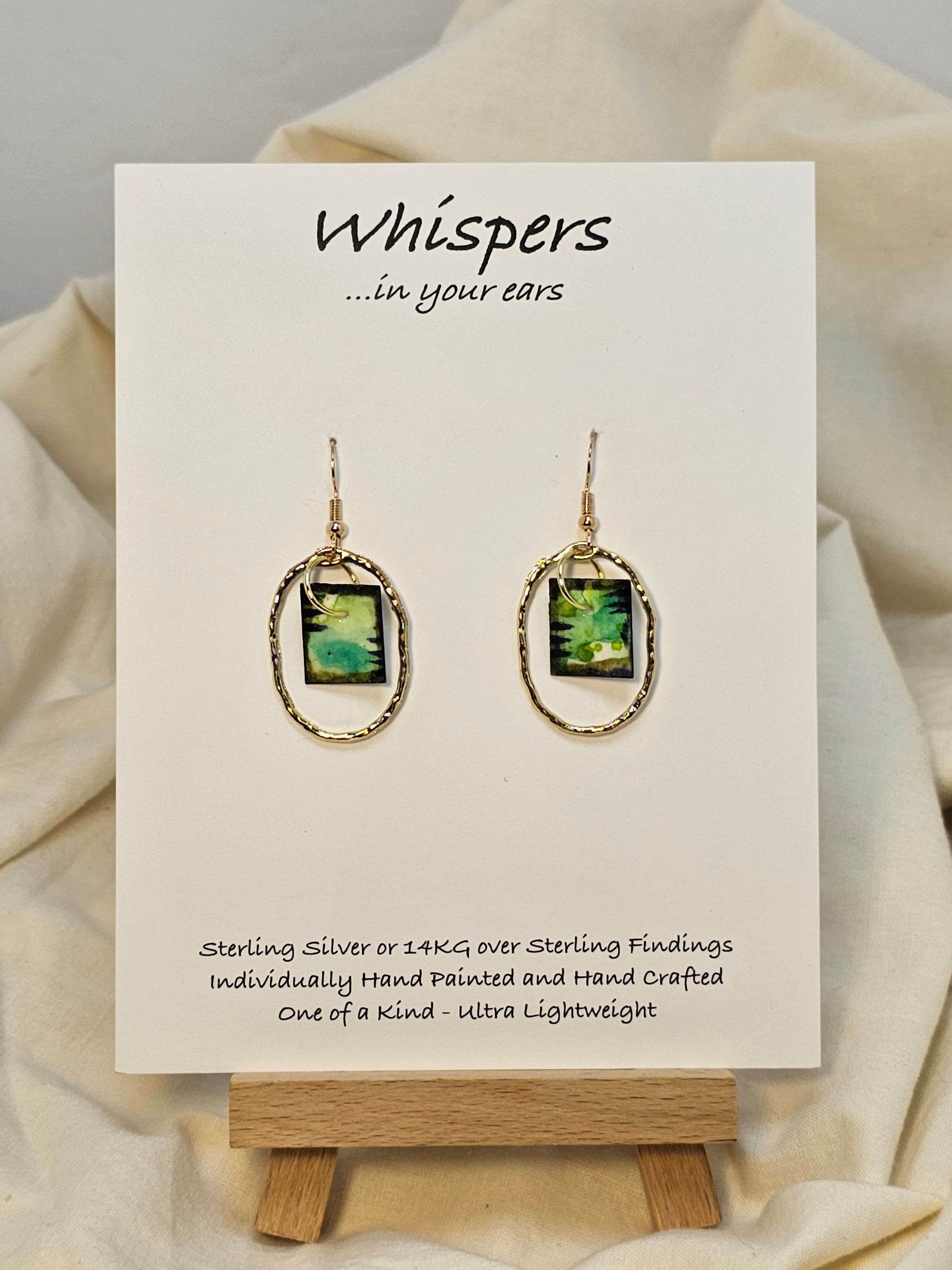 Gold Alloy Oval Mini Hand Painted Paper Earrings. Small painting in Aqua blue, brown, black and lime green. Hanging from the center of Gold alloy oval. Back is painted to match. Ultra lightweight. Resin coating for durability. 14KG over sterling findings. Hangs 1 1/4" in length