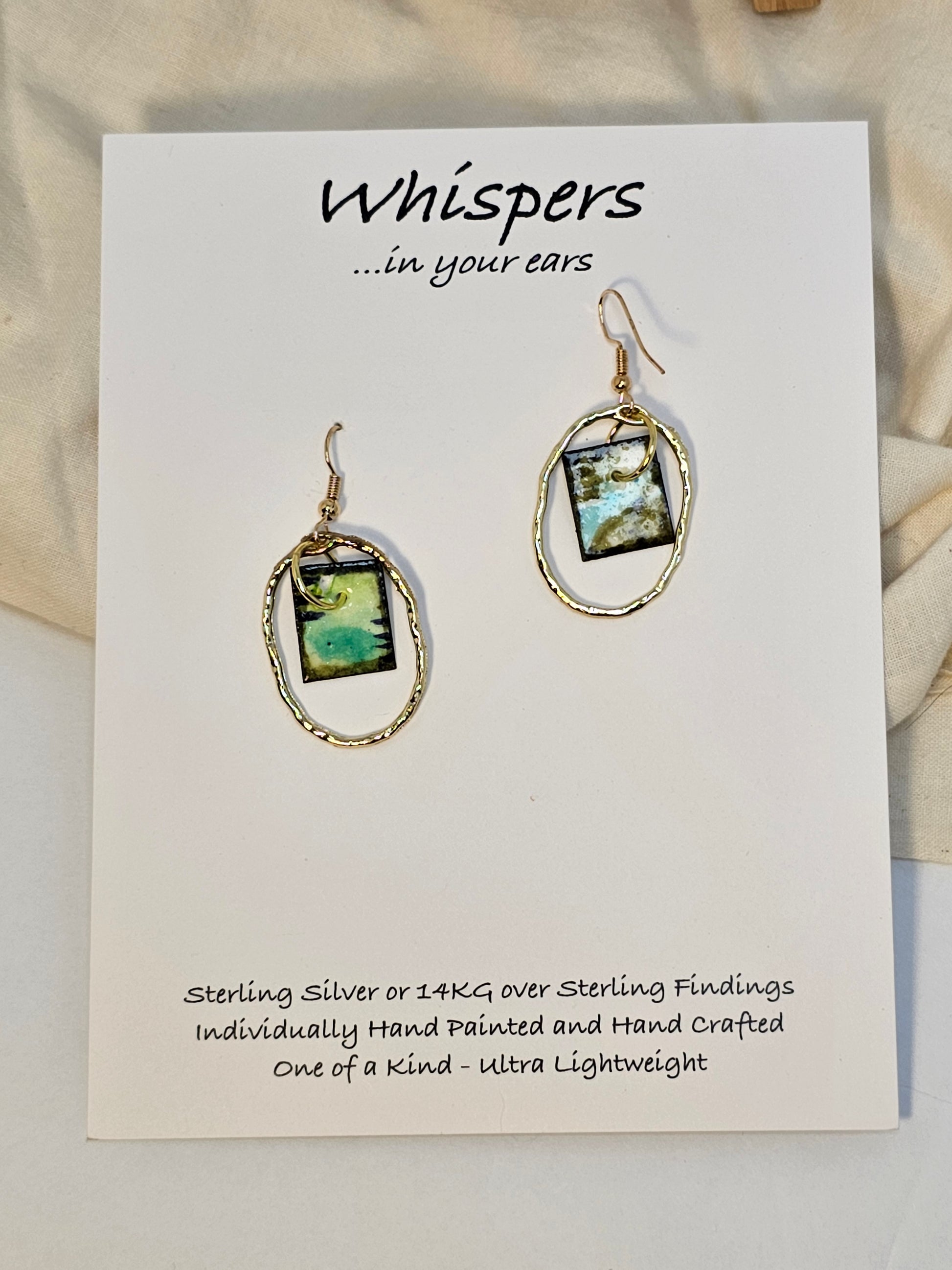 Gold Alloy Oval Mini Hand Painted Paper Earrings. Small painting in Aqua blue, brown, black and lime green. Hanging from the center of Gold alloy oval. Back is painted to match. Ultra lightweight. Resin coating for durability. 14KG over sterling findings. Hangs 1 1/4" in length