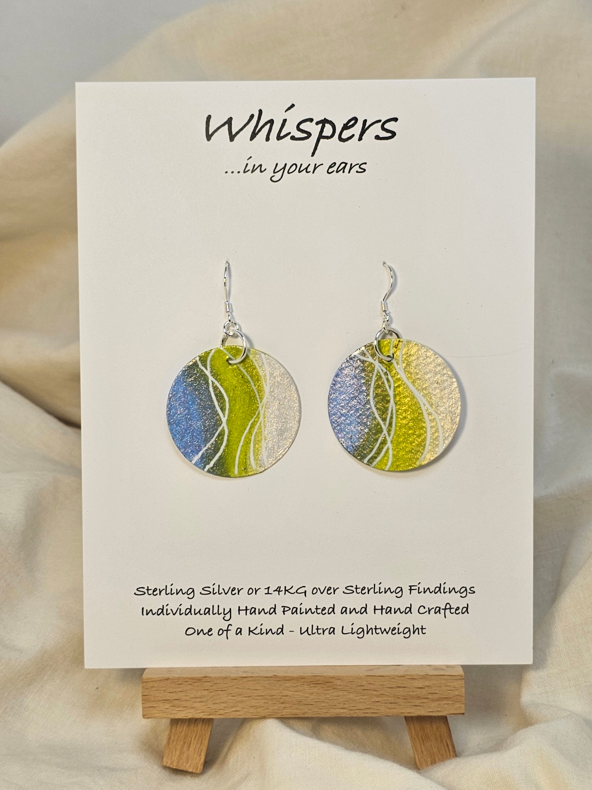 Pearl Swirl Iridescent Hand Painted Watercolor Paper Earrings. Ultra lightweight 1 1/4" Circle abstract watercolor painting periwinkle blue, lime green and pearlized white accents. Back is painted to match. Resin coating for durability. Sterling findings. Hangs 1 1/2" in length