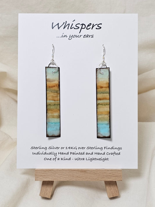 Vintage Beach Reflections Hand Painted Paper Earrings. Ultra lightweight 1/2" x 2 1/2" elongated rectangle. Watercolor abstract beach reflection. Distressed edge in brown. Back is painted with similar design. Resin coating for durability. Sterling Silver findings. Hangs 2 3/4" in length