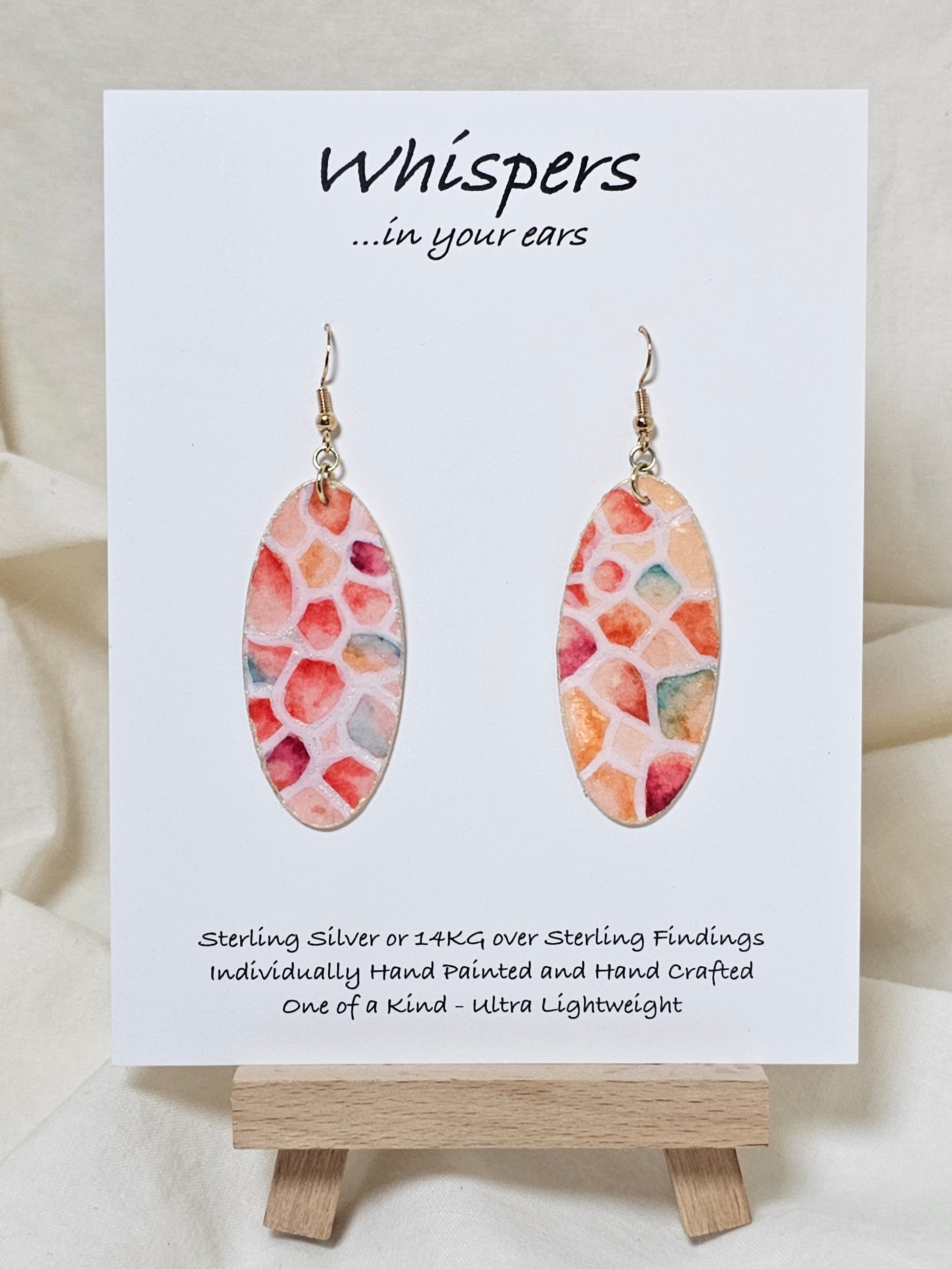 Wings Magnified Hand Painted Paper Earrings.&nbsp; Ultra lightweight 2" Elongated oval. Painted multicolored in pastels. Back is painted in white iridescent pearl. Resin coating for durability. Mixed metal findings Sterling silver and 14KG over sterling ear wires. Hangs 2 1/8" in length