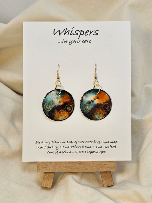 Gold Bullseye Hand Painted Watercolor Paper Earrings. Ultra lightweight 1 1/4" Circle abstract watercolor painting Deep blue, orange, brown and metallic gold bullseye accents. Back is painted to match. Edged in dark brown. Resin coating for durability. 14KG over sterling findings. Hangs 1 5/8" in length