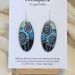 Silver Dandelion Puffball Hand Painted Wood Earrings. Geometric background in soft green, aqua blue and black. Back painted in similar design. Resin coated for durability. 2" Elongated oval wood. Sterling silver findings and hangs 2 1/4"