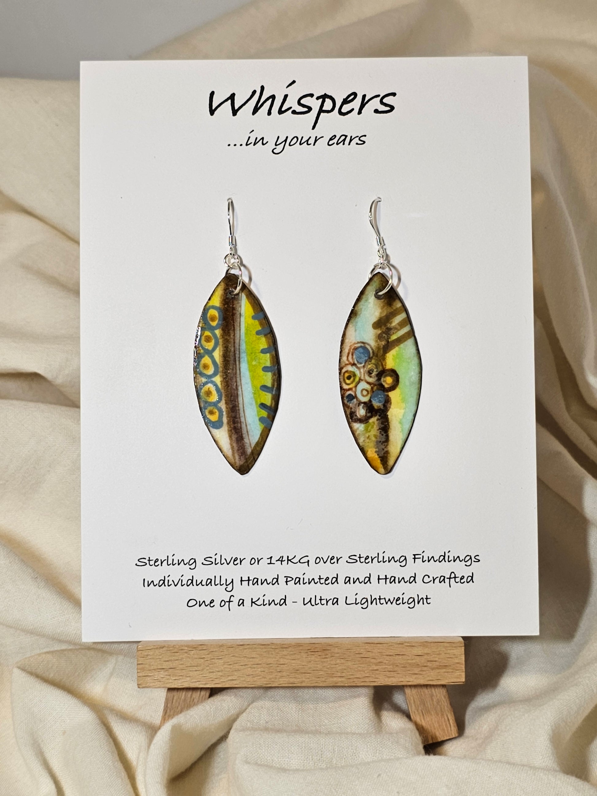 Boho Feather Hand Painted Paper Earrings. Multi colored blues, yellows and brows. Original designs on both sides. Resin coated for durability. Ultra lightweight. Sterling silver ear wires and findings. Hangs 1 3/4"