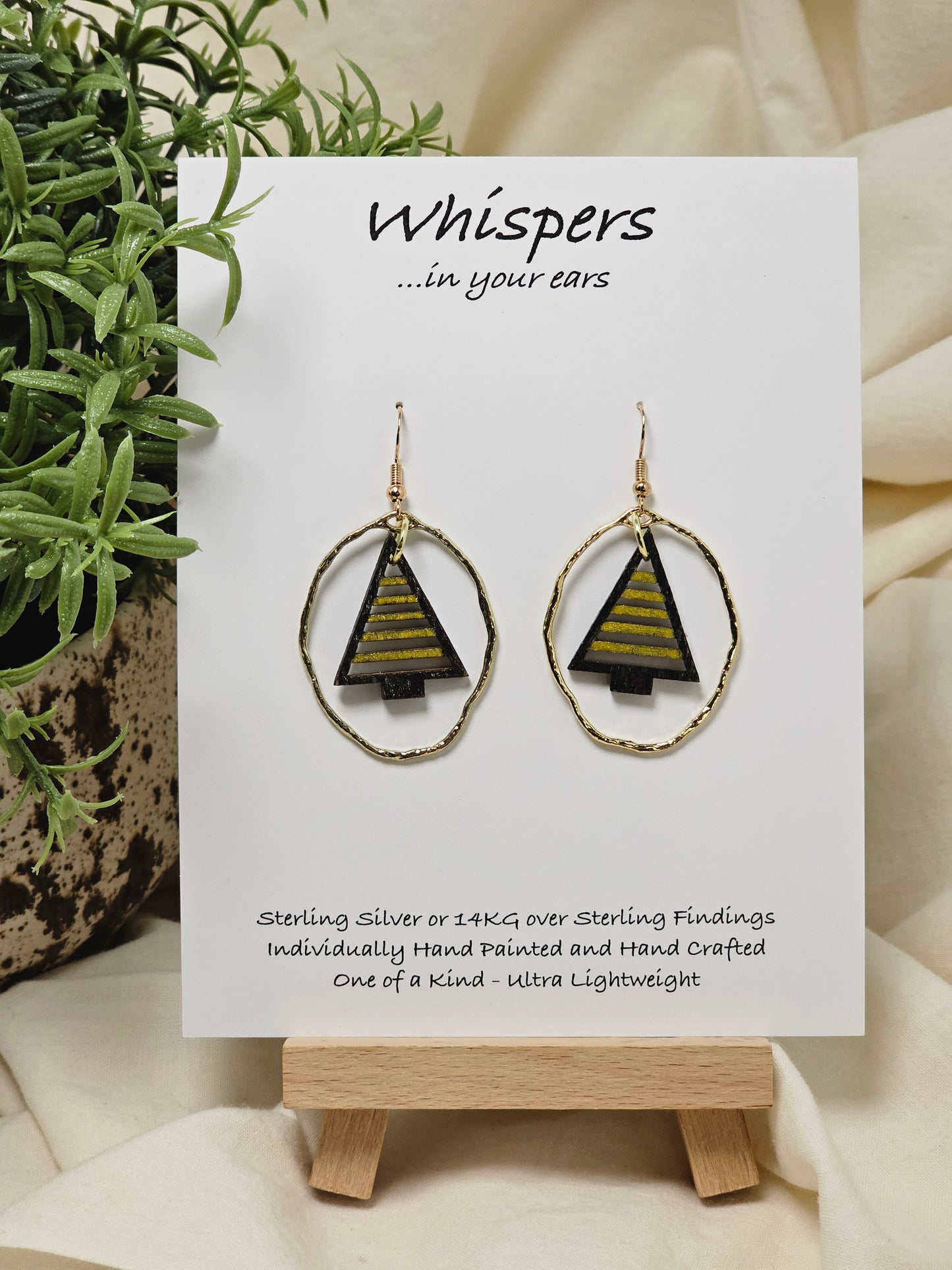 Gold Stripe Tree Hand painted/Crafted Wood Earrings. Christmas Tree die cut painted in black and gold. Dangling in a light weight gold alloy frame. Back is exactly the same. Enameled for durability. S14 KG over Sterling Silver ear wires and findings. Hangs 1 1/2"