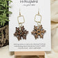 Vintage Snowflake Wood and Alloy Earrings. Ultra light weight. 1 1/2" Wood snowflake hand painted and distressed. Hangs from gold alloy square. 14kg ear wires and findings. Back of earring is painted in similar design. Enameled for durability. Hangs 2 1/2" in length