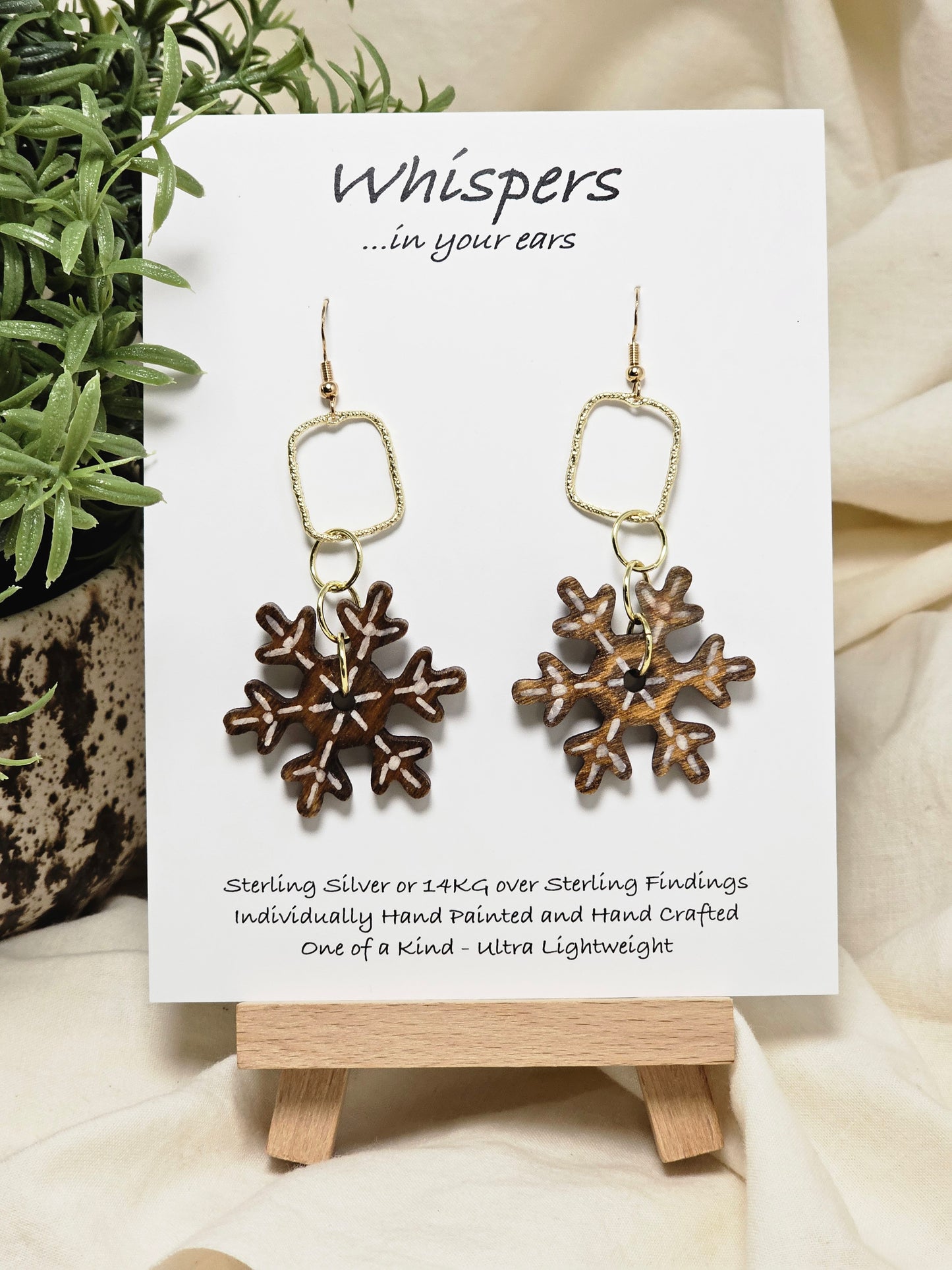 Vintage Snowflake Wood and Alloy Earrings. Ultra light weight. 1 1/2" Wood snowflake hand painted and distressed. Hangs from gold alloy square. 14kg ear wires and findings. Back of earring is painted in similar design. Enameled for durability. Hangs 2 1/2" in length